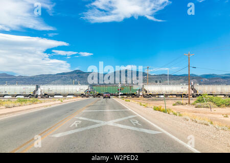 Alamogordo, USA - Juni 9, 2019: Neue Mexico City mit Bahnübergang auf die Bahn Mit dem Auto warten auf der Straße und der Blick auf den Sacramento Mountains Stockfoto