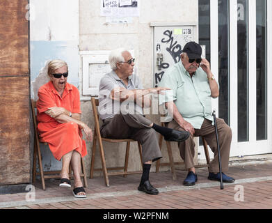 Zwei ältere Männer und eine Frau auf der Straße in Spanien sitzen Stockfoto