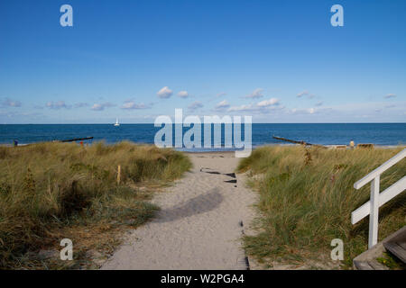 Strand an der Ostsee. Sandstrand Weg durch die Dünen zum Meer. Blauer Himmel und Meer im Hintergrund. Menschen am Strand Stockfoto