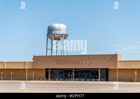 Brownfield, USA - Juni 8, 2019: Texas Landschaft industrielle Stadt mit alten Vintage heruntergekommenen Walmart und Wassertank mit Vorzeichen Stockfoto