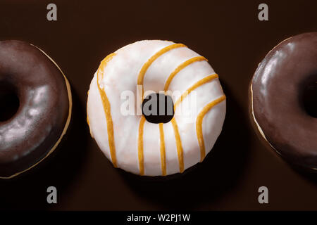 Close-up glasierte Donuts auf dunkle Schokolade Hintergrund. Stockfoto