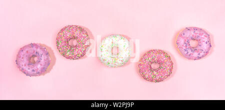 Muster der fünf glasierte Donuts auf sanfte rosa Hintergrund. Stockfoto
