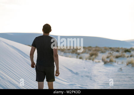 Mann zu Fuß zurück auf Sand in White Sands Dunes National Monument in New Mexico bei Sonnenuntergang auf der Suche Stockfoto