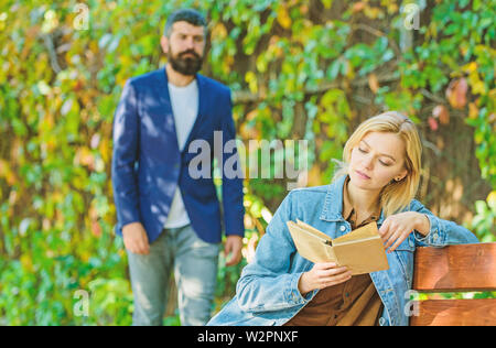 Buch lesen. Feder Stimmung. Mädchen mit Buch auf der Werkbank. bärtiger Mann Spaziergang im Park. Imagination und Inspiration. Deep in Love Story. Paar Liebesgeschichte. Paar im Park. Paar Freunde treffen Outdoor. Stockfoto