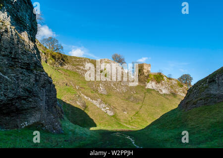 Peveril Castle sitzt hoch oben Höhle Dale, einem natürlichen trockenen Tal/Schlucht durch reef Kalksteine in Castleton, Peak District. Stockfoto