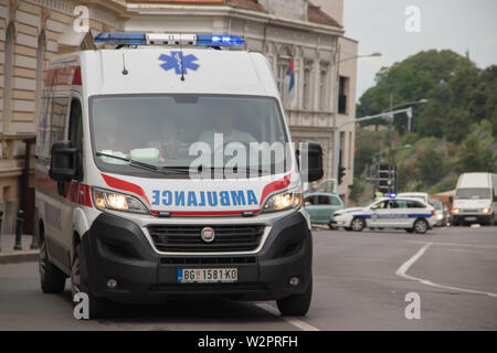 Rettungswagens auf der Straße, mit der Polizei im Hintergrund, Sicherung der öffentlichen Veranstaltung in Belgrad Stockfoto
