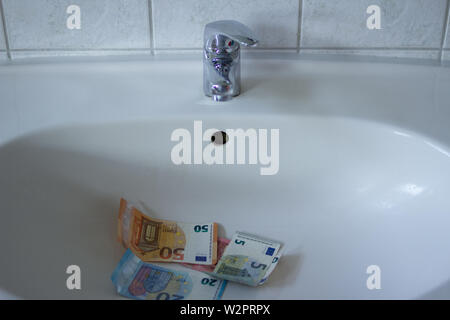 Close up Chrom Waschbecken mit Euro-Banknoten. Konzept für die Erhöhung der Wasserpreise und Haushalt Budgetplanung. Steigender Verbrauch Stockfoto