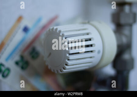 Close up-Thermostat mit Euro- Banknoten im Hintergrund. Energie Preis erhöhen. Haushalt Budgetplanung. Grüne Energie Stockfoto