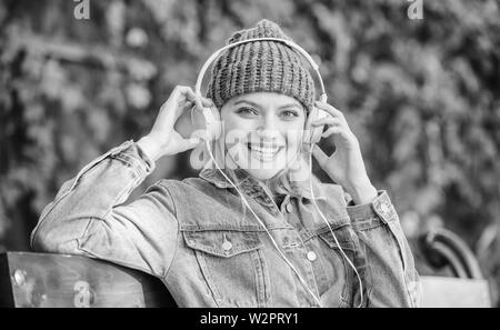 Leute Hörbücher vom mobilen Gerät und Computer anhören. Moderne Technik statt lesen. Hörbuch. Musik im Park anhören. hipster Mädchen mit mp3-Player. hipster Frau in Kopfhörer. Stockfoto