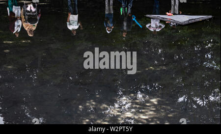 Berlin, Deutschland. 10. Juli 2019. Besucher stand auf dem Teich auf dem Gelände der Gedenkstätte für die Sinti und Roma in der Zeit des Nationalsozialismus im Tiergarten ermordet. Bisher unbekannte Täter beschädigten eine Glasscheibe auf das Denkmal am Abend. Die Sicherheit des Staates die Polizei ermittelt. Credit: Paul Zinken/dpa/Alamy leben Nachrichten Stockfoto