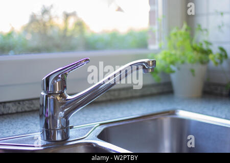 Moderne Küche mit schönen Blick auf den Garten. Chrom Küchenspüle. Moderne Küche Konzept. Stockfoto