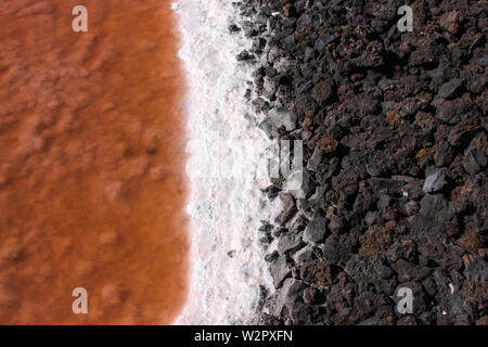 Nahaufnahme von der Grenze von einer Salzpfanne in den Farben schwarz, weiß und orange | Das Wasser bereits teilweise verdampft ist Stockfoto