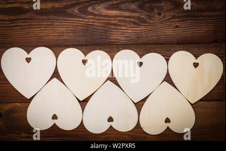 Holz- Herzen schön auf einem hölzernen Hintergrund platziert. Stockfoto