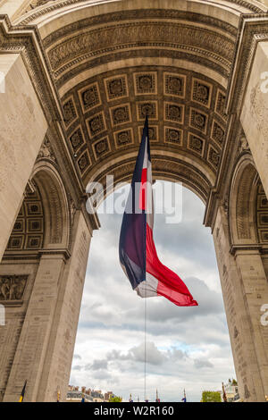 Nahaufnahme unter dem Arc de Triomphe de l'Étoile in Paris mit einem großen französischen Flagge während der Zeremonie das Opfer eines unbekannten französischen zu erinnern... Stockfoto