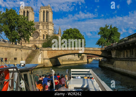 Herrliche Sicht auf die berühmte Kathedrale Notre-Dame de Paris von einem Schiff auf der Seine. Touristen sind zu bewundern und die Bilder von der ... Stockfoto