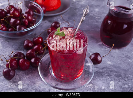 Glas mit frischen, hausgemachten Cherry sweet Eistee oder Cocktail, Limonade mit Minze. Erfrischenden kalten Getränk. Summer Party. Close Up. Stockfoto