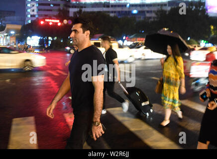 (190710) - YIWU, Juli 10, 2019 (Xinhua) - Aziz (L) Spaziergänge entlang der Straße in Fuzhou City, der ostchinesischen Provinz Zhejiang, 9. Juli 2019. Aziz Ullah, 41, kam nach Yiwu Stadt im Osten der chinesischen Provinz Zhejiang im Jahr 2003 mit seinem Partner nach seinem Abschluss von der Universität in seiner Heimat Afghanistan. Es war sein erstes Mal zu Yiwu zu kommen für smallware zu kaufen. 2005, Aziz begann seine eigene Firma, nachdem sie einem Agenten für ca. 2 Jahre. In den letzten Jahren und der Antriebsriemen Straße Initiative hat gewaltige Chancen für Aziz von Unternehmen gebracht. Er kaufte mehr als 200 Container der Artikel ein Jahr und Stockfoto