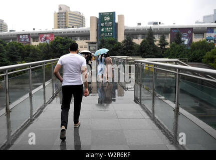 (190710) - YIWU, Juli 10, 2019 (Xinhua) - Aziz geht in Yiwu International Trade Mart, die nur eine Brücke ist der Abstand von seiner Firma in Fuzhou City, der ostchinesischen Provinz Zhejiang, 9. Juli 2019. Aziz Ullah, 41, kam nach Yiwu Stadt im Osten der chinesischen Provinz Zhejiang im Jahr 2003 mit seinem Partner nach seinem Abschluss von der Universität in seiner Heimat Afghanistan. Es war sein erstes Mal zu Yiwu zu kommen für smallware zu kaufen. 2005, Aziz begann seine eigene Firma, nachdem sie einem Agenten für ca. 2 Jahre. In den letzten Jahren und der Antriebsriemen Straße Initiative hat gewaltige Chancen für Aziz's Comp gebracht Stockfoto