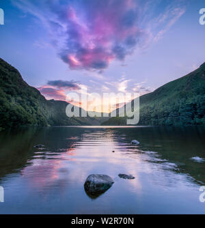 Glendalough, co. Wicklow / Irland - wunderschöne Spiegelung des Himmels im Wasser des Upper Lake im Glendalough Valley bei Dämmerung Stockfoto