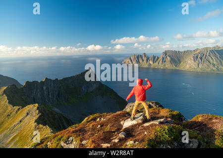 Mann mit verschränkten Armen in der Feier verteilt auf der Oberseite des Berges, der Insel Senja, Troms Stockfoto