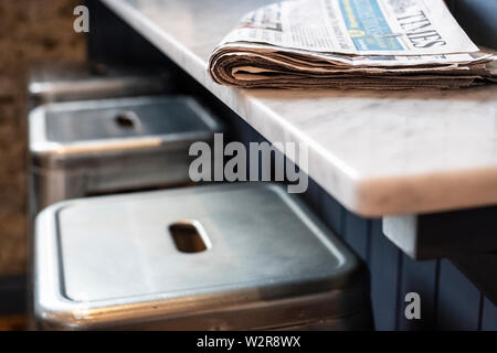 Nahaufnahme von drei Hocker an der Theke, gefaltete Zeitung auf. Stockfoto