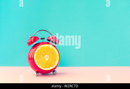 Sommer Konzepte zeit Ideen mit orange Wecker auf Blau pastell Hintergrund. Stockfoto