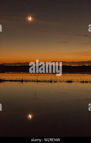 Nacht Landschaft im Albufera Lagune, die mit dem Mond und seiner Reflexion über Wasser im Naturpark Albufera, Valencia, Spanien Stockfoto