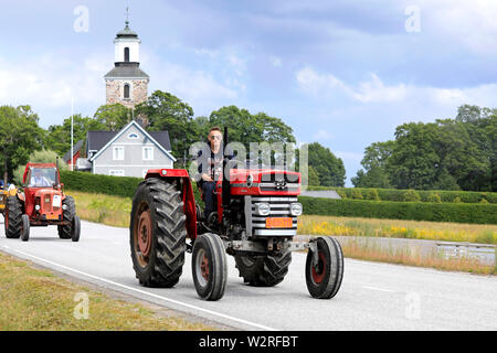 Kimito, Finnland. Juli 6, 2019. Junger Mann Laufwerke 178 Massey Ferguson Multi-Power Traktor auf Kimito Tractorkavalkad, vintage Traktor Show und Parade. Stockfoto