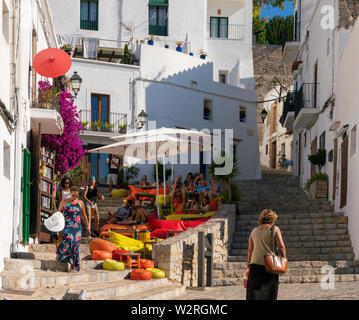 22.Juni 2019 - Ibiza, Spanien. Menschen entspannend auf die bunten weichen Bohne Beutel unter Sonnenschirmen im S'Escalinata Bar in der Stadt Ibiza entfernt Stockfoto