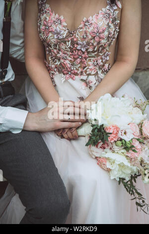 Der Bräutigam hält die Hand der Braut. Stockfoto