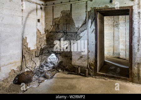 Nicht detonierte Shell ging durch die Wand des Bunker am Zweiten Weltkrieg Batterie d'Azeville/Azeville Batterie, Teil der Deutschen Atlantischen Mauer, Normandie, Frankreich Stockfoto