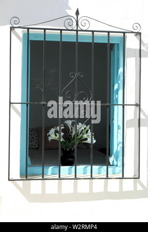 Dekorative Haus Fenster mit schmiedeeisernen Bars im Bergdorf Frigiliana, Málaga, in Spanien; am frühen Morgen an einem sonnigen Sommertag. Stockfoto