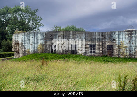 Tarnanstrich, zerstörten Gebäude auf der Rückseite des Gun casemate/Artillerie Bunker des Zweiten Weltkriegs Batterie d'Azeville Batterie, Normandie, Frankreich Stockfoto