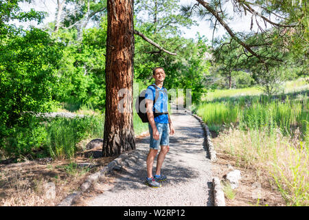 Landschaft von Baum und Pfad mit Mann Wandern am Main Loop Trail im Bandelier National Monument in New Mexico im Sommer in Los Alamos Stockfoto