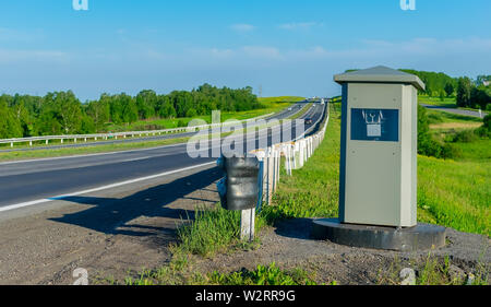 Rückfahrkamera zur Festsetzung der Bewegung von Autos aus Beschleunigung, die auf einer Landstraße im Sommer steht auf dem Hintergrund der vorbeifahrenden Autos Stockfoto