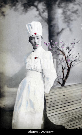 [1900s Japan - Japanische Rote Kreuz Krankenschwester] - eine Frau, die in der Uniform eines Roten Kreuzes Krankenschwester. Rote Kreuz Krankenschwestern waren ein Symbol der Moderne in den 1900er Jahren. Während des Russisch-Japanischen Krieges (1904-1905) Sie waren auch Ausdruck der Japan International lobte Engagement für humanitäre Ideale. Obwohl modern und neu, die fotografische Postkarten tatsächlich verewigt die alte Tradition der Bijinga (美人画). Diese Bilder von schönen Frauen waren ein etabliertes Genre der ukiyoe Holzschnitte. 20. jahrhundert alte Ansichtskarte. Stockfoto
