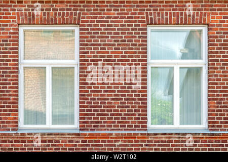 Zwei rechteckigen Fenstern mit weißen Rahmen auf einem roten Ziegelwand Hintergrund. Vom Fenster aus der Serie der Welt. Stockfoto