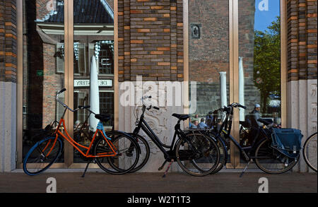 Groningen, Groningen/Niederlande - Oktober 12, 2018: Fahrräder vor der Glastür reflektiert die Fassade des historischen Martini Kirche (Mart geparkt Stockfoto