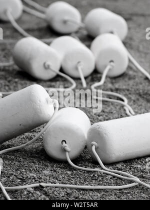 Bojen auf Seilen an der Küste Strand gesäumt und bereit, in Meerwasser zu Beginn der Badesaison. Stockfoto