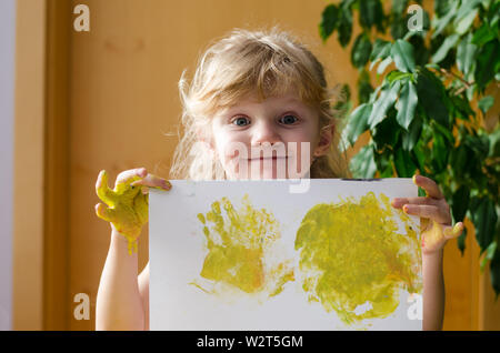 Blonde Mädchen mit gemalten Bild in der Hand Stockfoto