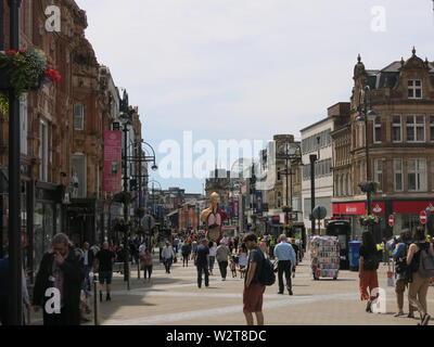 Foto der Käufer auf Briggate in Leeds, einer belebten Hauptstraße mit zahlreichen Kundenfrequenz an einem Donnerstag Morgen im Juli 2019 Stockfoto