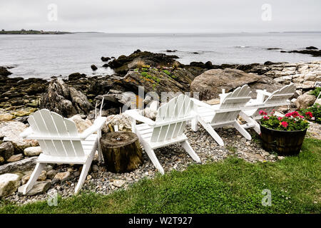 Adirondack Stühle, die auf der felsigen Küste der Bucht im Ocean Point in Boothbay, Maine. Stockfoto