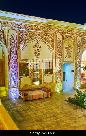 KASHAN, IRAN - Oktober 23, 2017: Die Mauer des Mahinestan Raheb historischen Haus mit fein geschnitzten und bemalten Muster und Arabesken gedimmt Abend Stockfoto