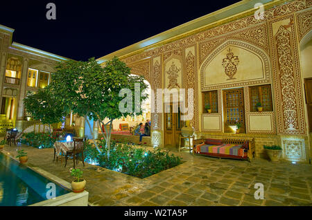 KASHAN, IRAN - 23. OKTOBER 2017: Besuchen Sie das Restaurant in Mahinestan Raheb historischen Haus mit Lounge Zone im malerischen Innenhof, verziert mit geschnitzten Stockfoto