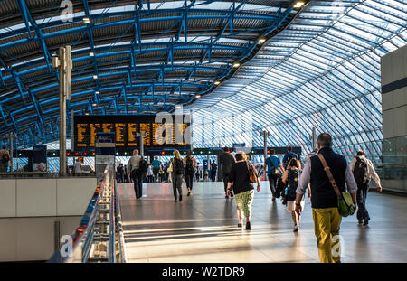 WATERLOO STATION Pendler, Besucher in die neue Architektur Plattform Ergänzungen 20-24 im ehemaligen Eurostar Terminal entfernt. Moderne langen Abfahrten Bahnhofshalle mit bahnreisende auf dem Weg zum Abflug Plattformen am späten Nachmittag Sonne, Network Information Bildschirme im Hintergrund Waterloo Station London SE1 Stockfoto