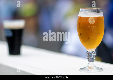 Wimbledon, London, UK. 10. Juli 2019. 10. Juli 2019, den All England Lawn Tennis und Croquet Club, Wimbledon, England, Wimbledon Tennis Turnier, Tag 9; ein frisches Glas Bier steht auf einem Geländer an einer der Bars mit Blick auf einen Hof Stockfoto