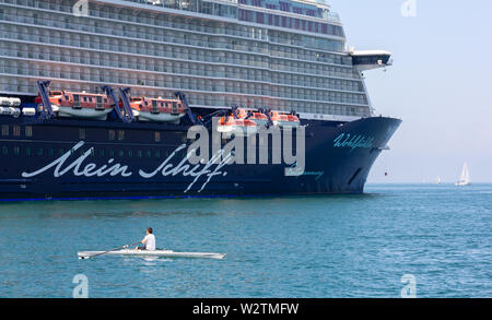 Triest, Italien, 16. Juni 2019: Rower Vor dem Kreuzfahrtschiff Mein Schiff 6 Neben Audace Pier auf der Stadt direkt am Meer günstig Stockfoto