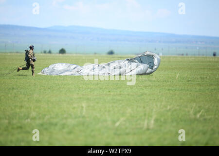 Boboc, Rumänien - 22. Mai 2019: Rumänische militärische Fallschirmjäger landen nach einem Sprung von einer Armee Flugzeug, während einer Räumungsübung. Stockfoto