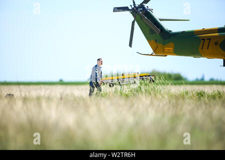 Boboc, Rumänien - 22. Mai 2019: Rumänische Soldaten und Sanitäter, mit einem Krankenwagen und einem IAR330 Puma Helikopter nehmen Sie teil an einem Bohren. Stockfoto