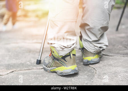 Reisenden zu Fuß auf den Felsen im Wald in den Bergen/Man Wanderer Beine und Füße in Schuhe Stockfoto